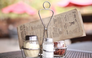 Folded menu with salt, pepper and Parmesan dispensers.