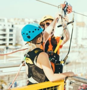 two women clipping into a zip line