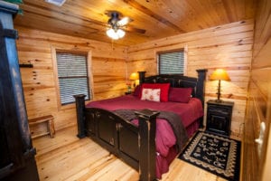 A cozy pine-paneled bedroom.