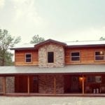 A photo of the lodge, two-story wood frame with large stone front section.