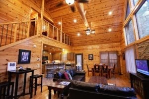 The light wood-paneled two story living area of the cabin.