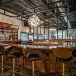 Looking into the bar area with a u-shaped bar and high-top chairs.