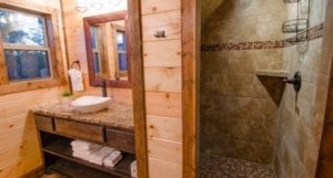 One of the private baths, featuring tile and stone walk-in shower and sink.