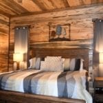 One of the king beds in a wood-paneled bedroom.