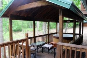 A sitting area and the hot tub on the covered deck.