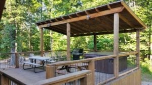 The covered deck with table, chairs and covered hot tub.