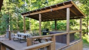 The covered deck with table, chairs and covered hot tub.