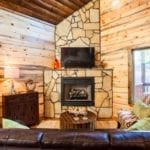 The floor-to-ceiling stone fireplace in the corner of the living room area.