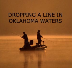 Two men fishing from a boat at dawn.