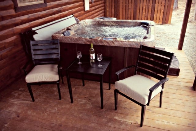 two chairs and wine on a tabel in front of a hot tub