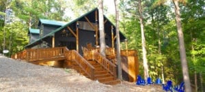 The exterior of Stream Life cabin which shows a tall staircase and wraparound porch.