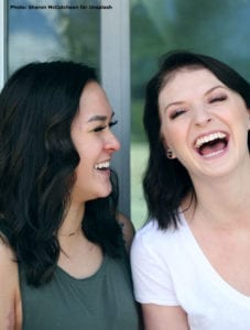 Two 20-something women laughing.