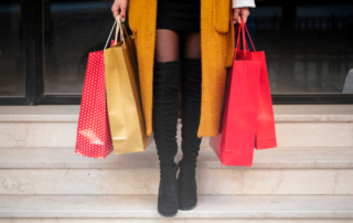 Woman holding shopping bags outside Oklahoma Boutiques