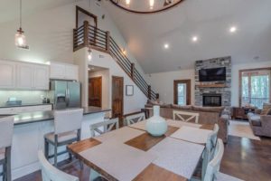 The dining and living room area of a cabin rental to relax in while looking up what to do in Broken Bow.