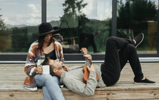 A couple relaxing on the porch of one of the best Broken Bow cabins for 2.