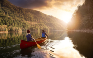 Two people canoeing down the Mountain Fork River.