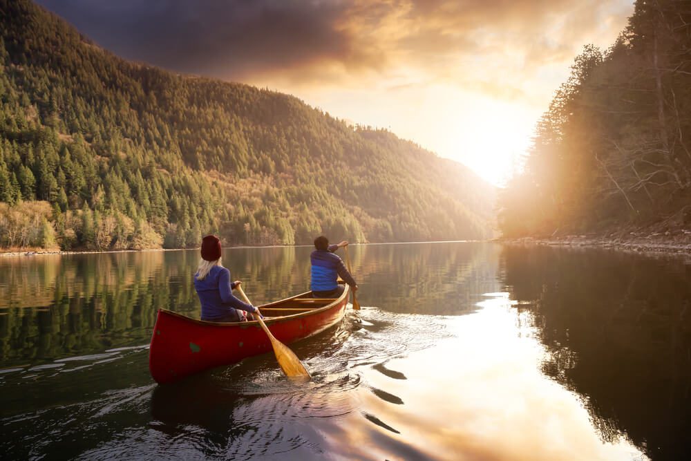 Two people canoeing down the Mountain Fork River.