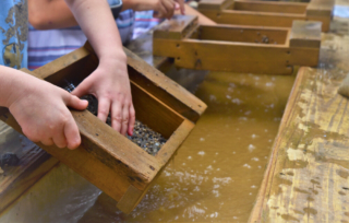 A kid panning for hidden treasures, one of the best things to do in Hochatown, OK.