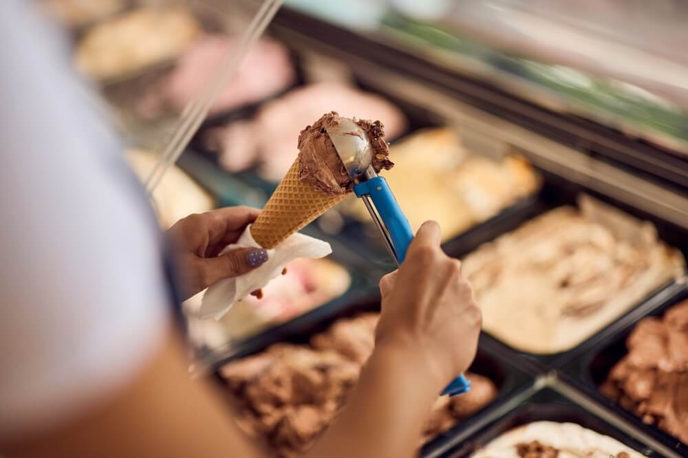 A person scooping ice cream at a Hochatown shop.