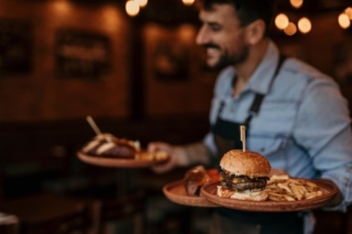 A server carrying plates of food at a Hochatown restaurant.