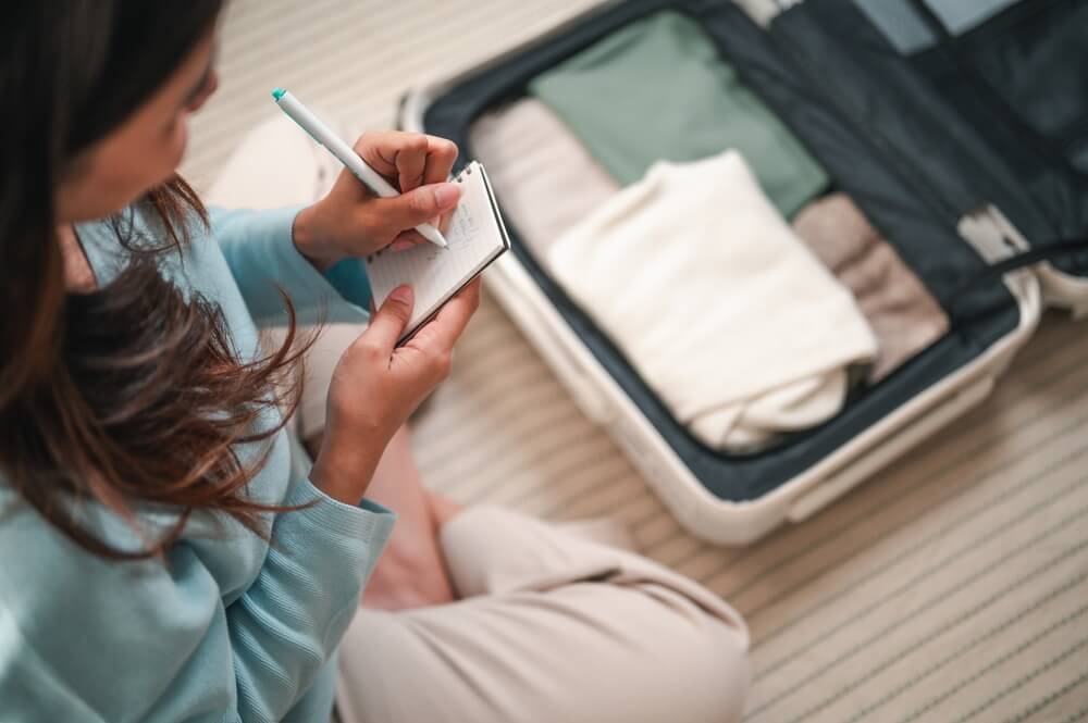 A woman making a list of what to pack for one of her Oklahoma vacations to Hochatown.