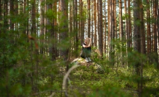 A person forest bathing and experiencing its benefits in Hochatown.