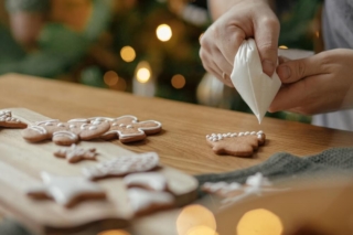 A person decorating Christmas cookies in an Oklahoma cabin rental.